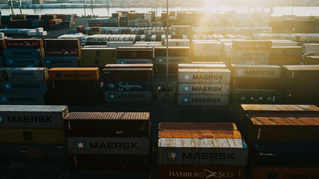 Aerial shot of stacked shipping containers in Philadelphia port at sunset.